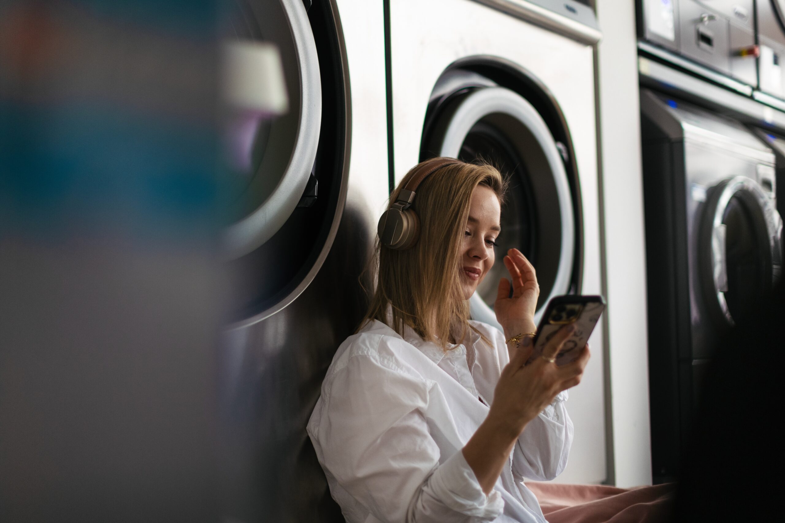 Young,Woman,Listening,Music,,Waiting,In,A,Laundry,Room.
